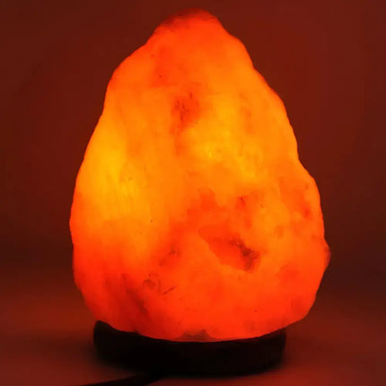 Close-up of a glowing 1-2kg Himalayan salt lamp on a smooth timber base.