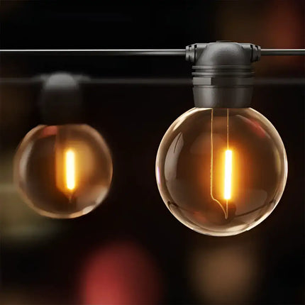 Round glowing string lights from the 17m Black Solar Festoon String Lights with 15 Bulb Plug in Kit