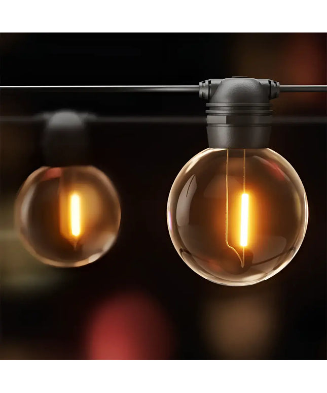 Round glowing string lights from the 17m Black Solar Festoon String Lights with 15 Bulb Plug in Kit