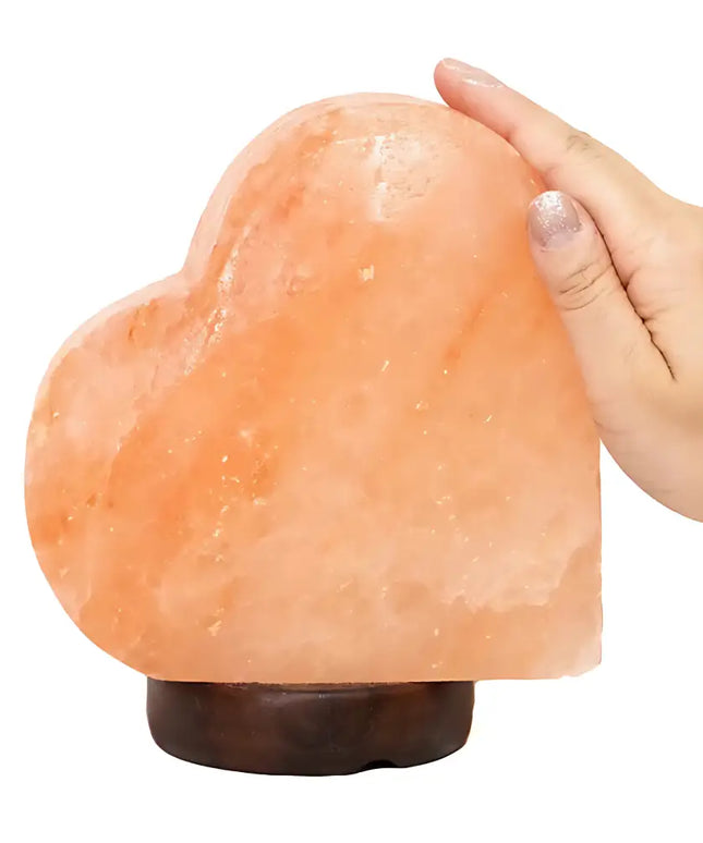 Sideways heart-shaped Himalayan salt lamp on a timber base, glowing softly in a romantic setting. Sydney Australia.