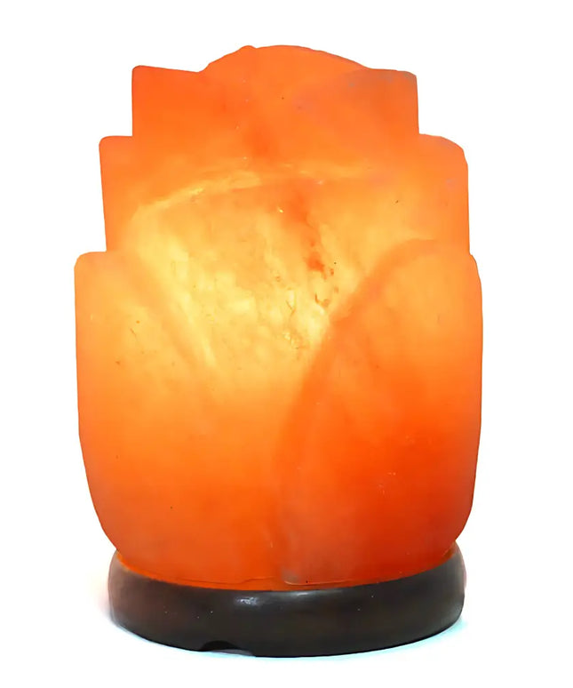 Rose-shaped Himalayan salt lamp with a timber base, glowing warmly in a cozy setting.