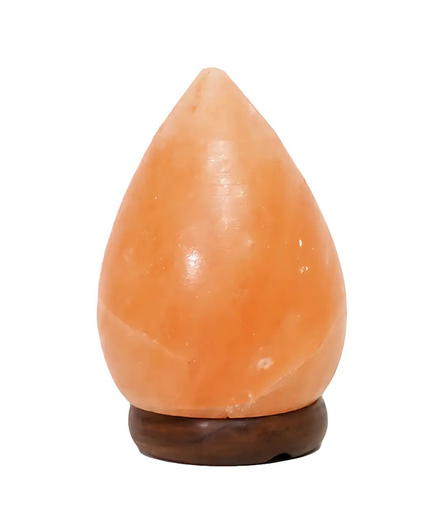 Pear-shaped Himalayan salt lamp with a timber base, glowing warmly in a cozy setting.
