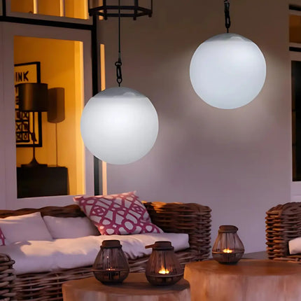 Weatherproof solar ball lights with built-in light sensors glowing in a backyard setting.