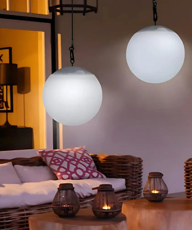 Weatherproof solar ball lights with built-in light sensors glowing in a backyard setting.