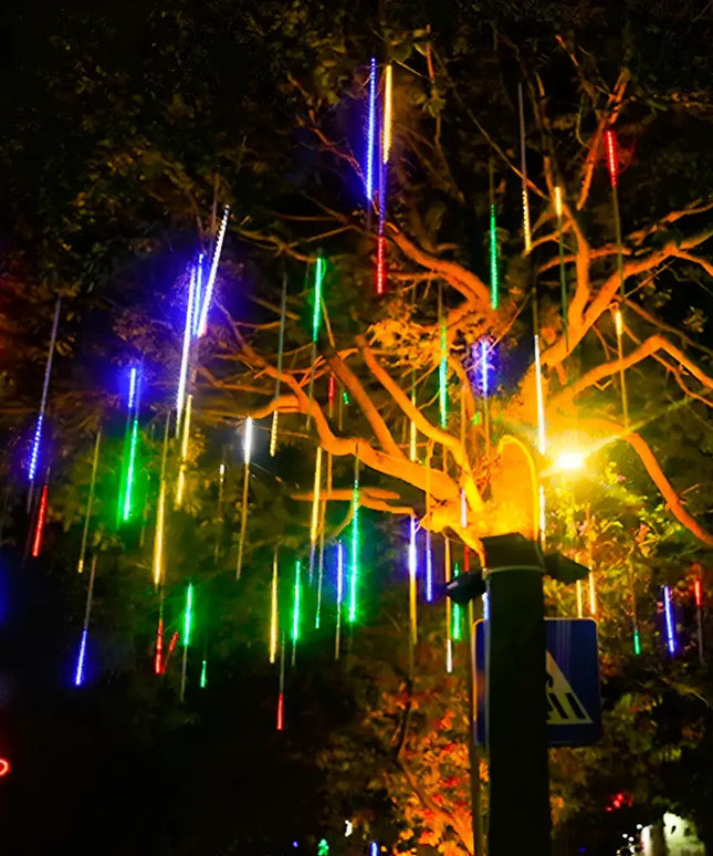 Colorful meteor shower string lights hanging from a tree for outdoor Christmas decoration
