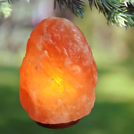 Authentic natural-shaped Himalayan salt lamp with a soft amber glow.