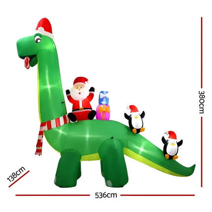 Inflatable Christmas Dinosaur decorated with Santa and penguins, illuminated for festive decor