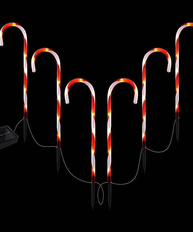 Solar-powered candy cane pathway lights illuminating garden pathways for festive decoration
