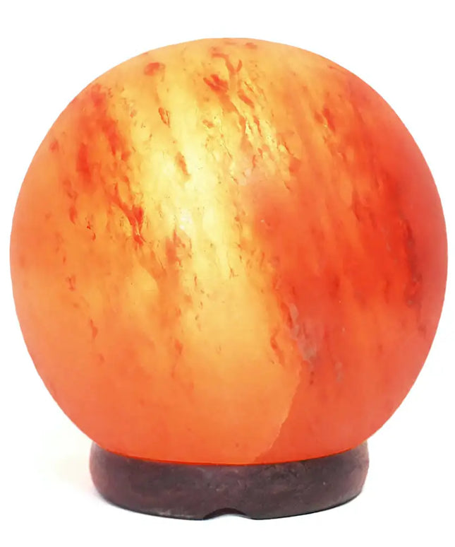 Hand-crafted sphere salt lamp showcasing natural pink hues on a wooden table.