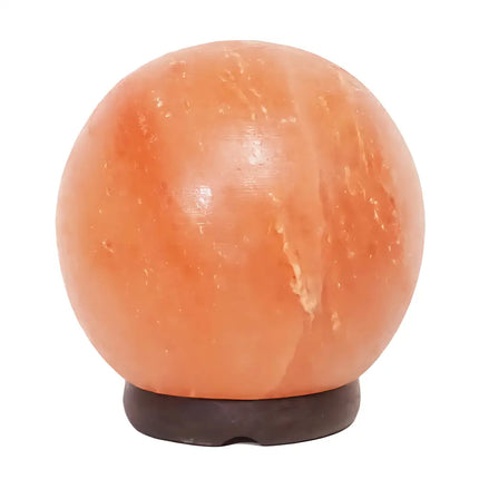6-inch sphere Himalayan salt lamp on a timber base glowing warmly in a serene bedroom.