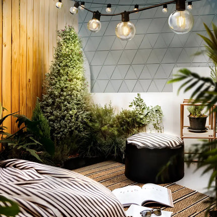 Outdoor seating area illuminated by 68m Black Festoon String Lights with 70 bulbs