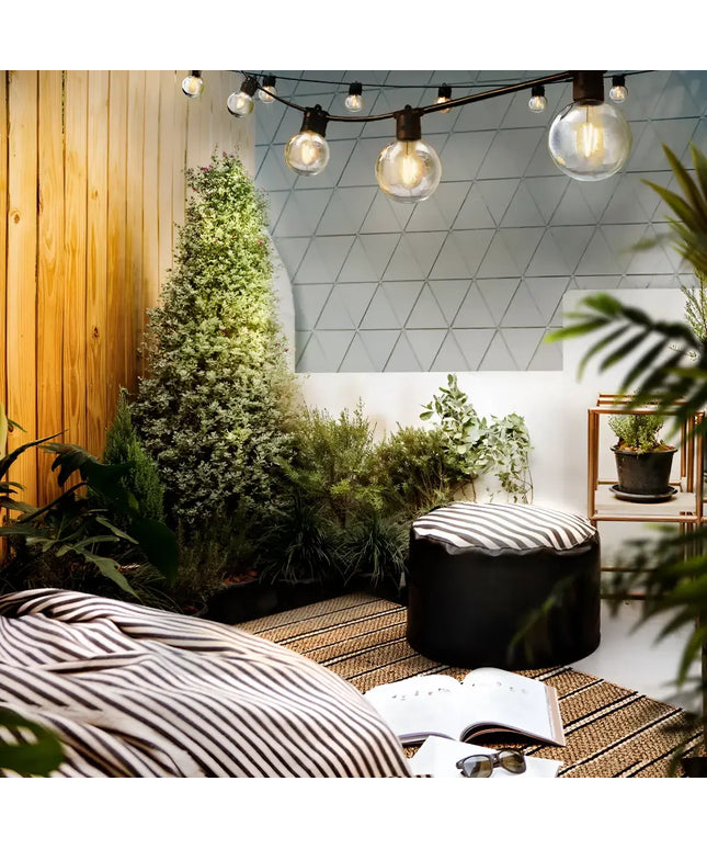 Outdoor seating area illuminated by 68m Black Festoon String Lights with 70 bulbs