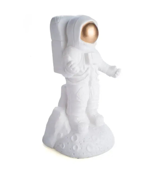 Portable astronaut LED lamp glowing in a dark bedroom setting