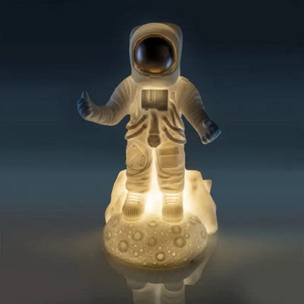 Space-themed night light featuring an astronaut on a dimpled moon base