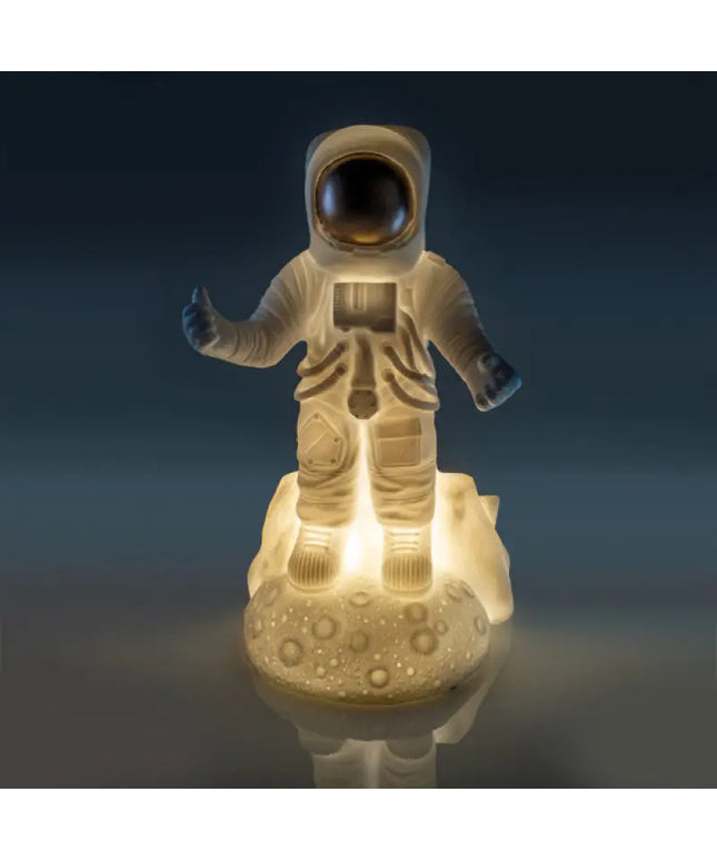 Space-themed night light featuring an astronaut on a dimpled moon base