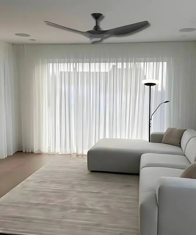 Modern living room with a ceiling fan, gray sectional sofa, and large windows.