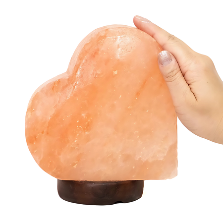 Sideways heart-shaped Himalayan salt lamp on a timber base, glowing softly in a romantic setting. Sydney Australia.