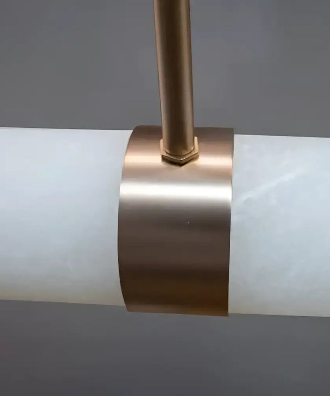Close-up of a cylindrical light fixture with a bronze band on a gray background