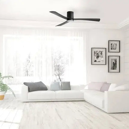 Modern living room with white sofa, ceiling fan, and framed pictures on a white wall.