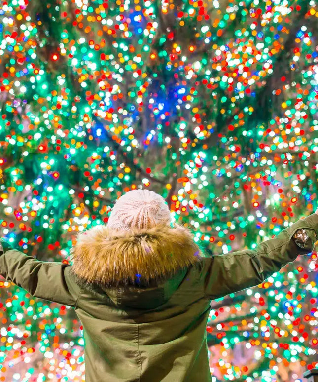 Person in winter coat enjoying Milano Decor outdoor multicoloured LED fairy lights before Christmas