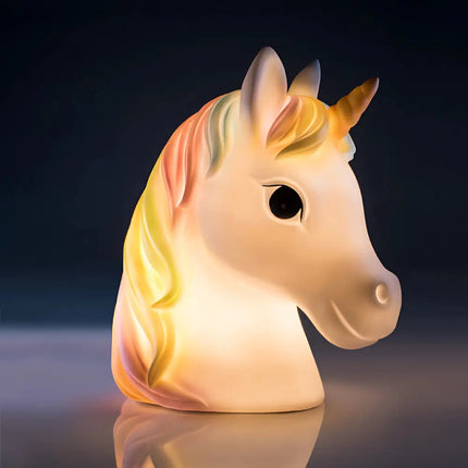 White unicorn LED lamp with a rainbow mane on a bedside table