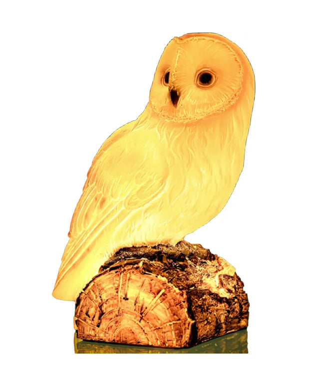 Snowy Owl Table Lamp glowing warmly in a dimly lit room