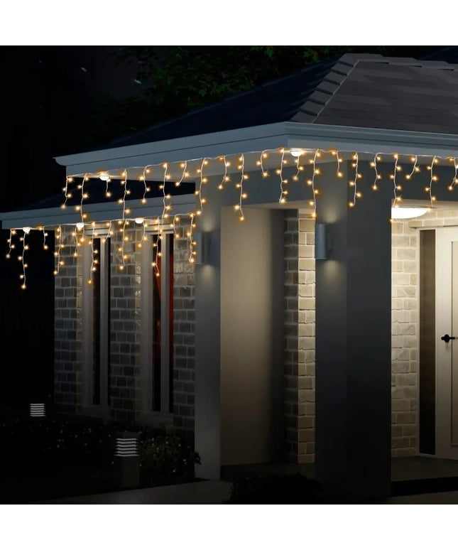 Illuminated icicle lights on house for festive decoration Solar 200 LED Cool White