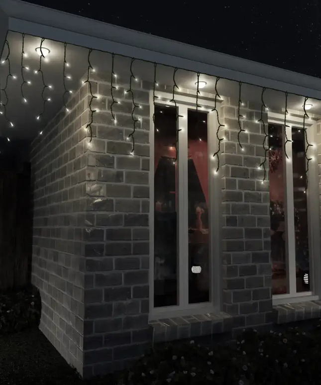 Brick building decorated with Solar 200 LED Icicle Lights in three colors at night