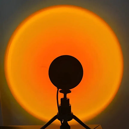 Sunset projection lamp on tripod displaying sunset red and rainbow effects