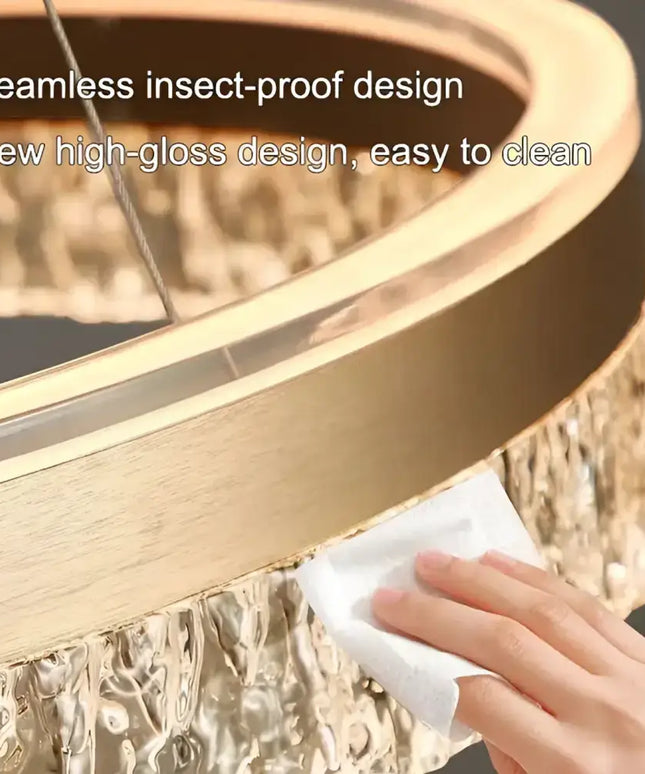 Circular gold chandelier being cleaned for the VICTORIA 180W Gold 3 Rings Water Ripple LED Crystal Chandelier